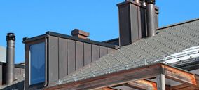 Detailansicht eines Daches mit Metall verblendeten Schornsteinen und eines hervorstehenden Fensters.